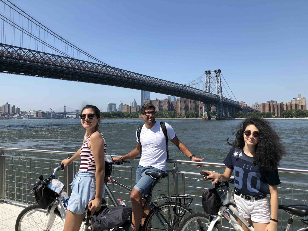 A family in front of Manhattan skyline during a bike tour with offbeat new york